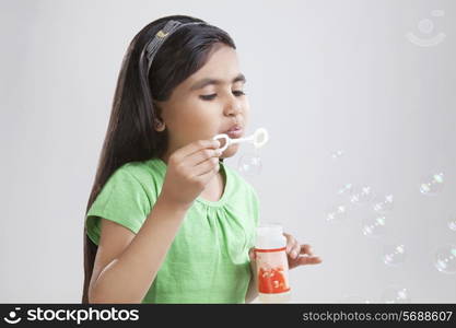 Little girl blowing bubbles