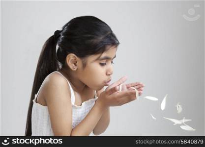 Little girl blowing petals out of her hand