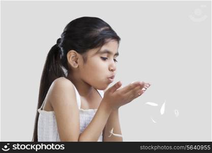 Little girl blowing petals out of her hand