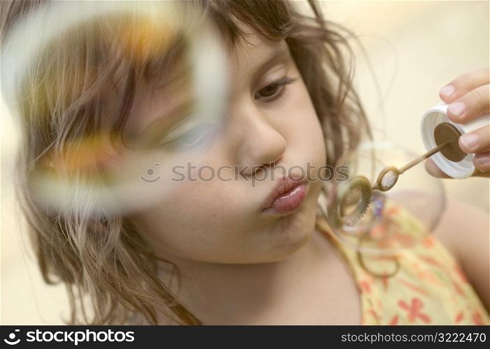 Little Girl Blowing Soap Bubbles