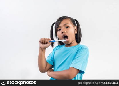 little girl brushing her teeth in studio shot