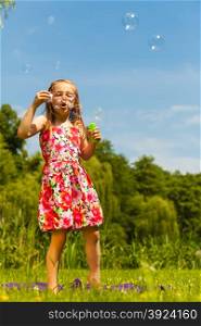 Little girl child blowing soap bubbles outdoor.. Little girl child blowing soap bubbles outdoor. Kid having fun in park. Happy and carefree childhood.