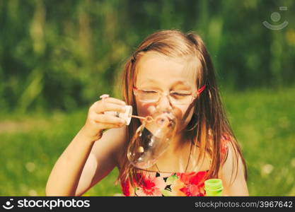 Little girl child blowing soap bubbles outdoor.. Little girl child blowing soap bubbles outdoor. Kid having fun in park. Happy and carefree childhood. Instagram filtered.