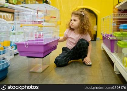Little girl child sitting nearby cage for rodent at pet shop searching new home for her adorable domestic animal. Little girl child sitting nearby cage for rodent at pet shop