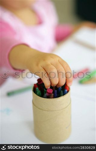 Little girl choosing a crayon