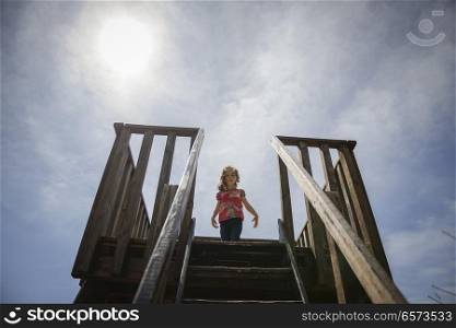Little girl climbing to a wooden observation tower in a wetland in Padul, Granada, Andalusia, Spain