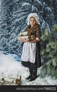 Little girl collects in the winter forest wood.. A child with logs of firewood in a snowy forest 4823.