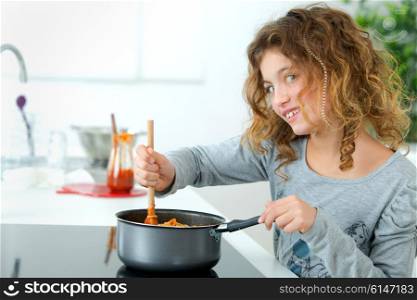 Little girl cooking spaghetti