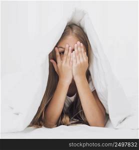 little girl covering her eyes blanket