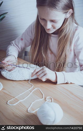 little girl crocheting a rug. knits crochet. leisure and hobby. Needlework