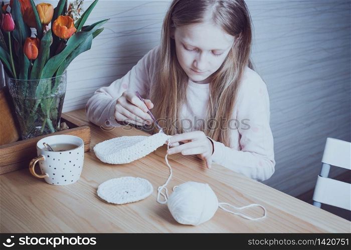 little girl crocheting a rug. knits crochet. leisure and hobby. Needlework