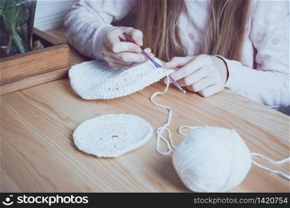 little girl crocheting a rug. knits crochet. leisure and hobby. Needlework