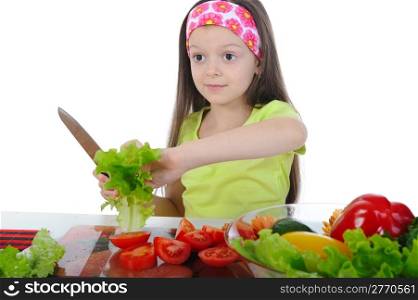 Little girl cut salad at the table. Isolated on white background