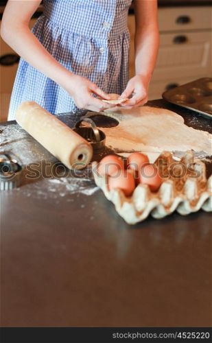 Little girl cutting out pastry for biscuits