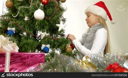Little girl decorating Christmas tree at home