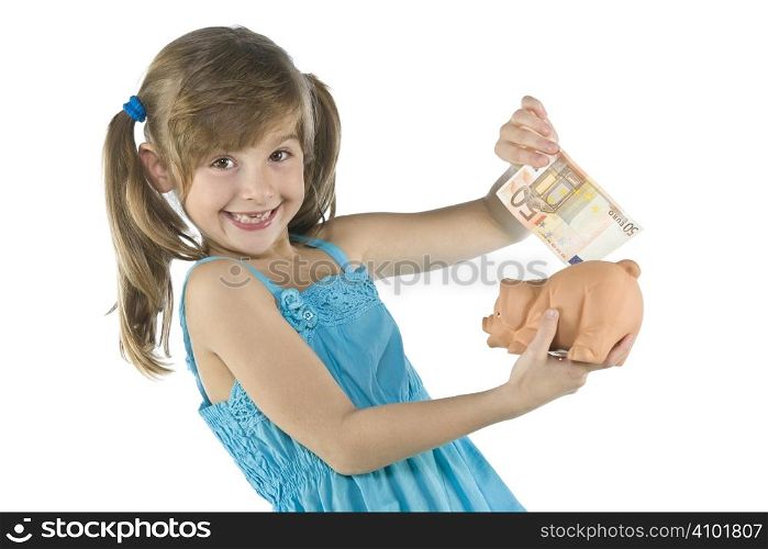 little girl depositing change in her piggy bank