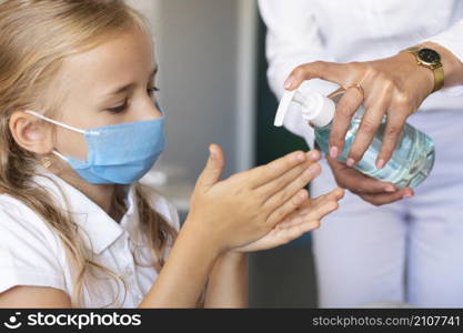 little girl disinfecting her hands