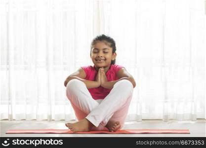 Little girl doing yoga at home