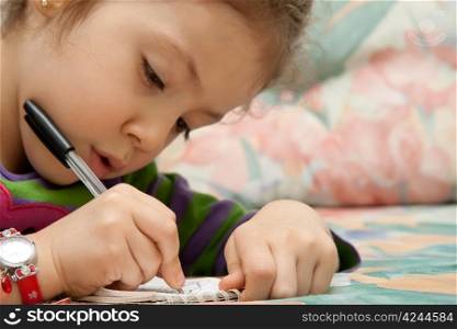 Little Girl Drawing Flowers On A Notebook