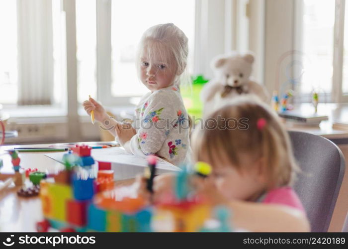 little girl drawing sitting table