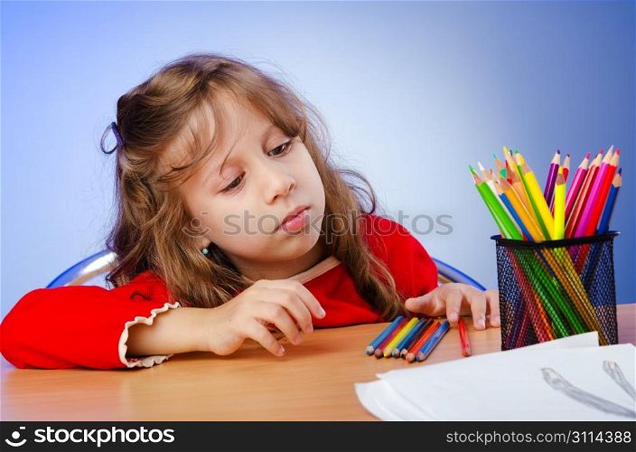 Little girl drawing with pencils