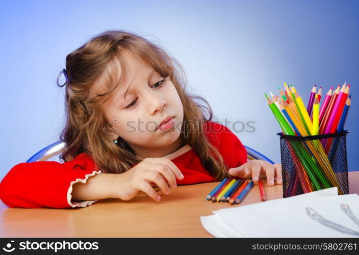 Little girl drawing with pencils