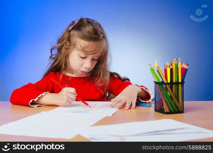 Little girl drawing with pencils