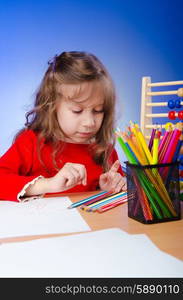 Little girl drawing with pencils