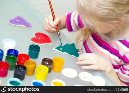 little girl draws sitting at the table