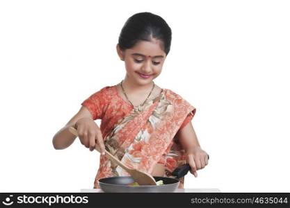 Little girl dressed as housewife cooking