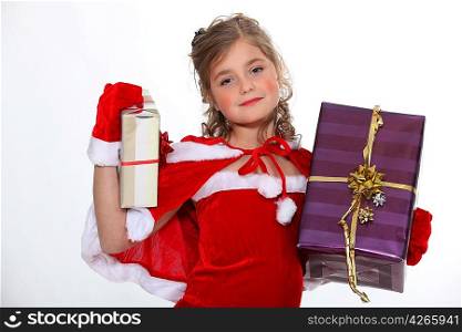 Little girl dressed in festive outfit carrying presents