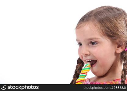 little girl eating a candy, looked amused and impish