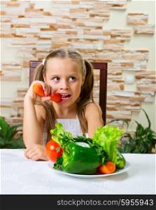 Little girl eating an vegetables at the table