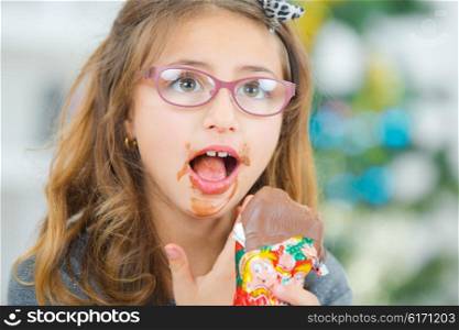 Little girl eating chocolate at Christmas
