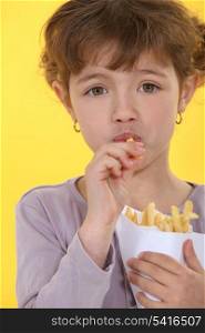 Little girl eating French fries