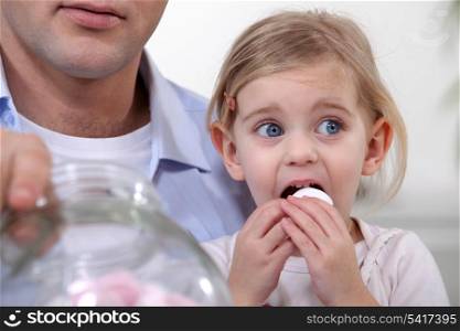 Little girl eating marshmallows