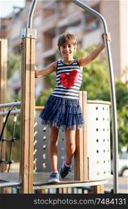 Little girl, eight years old, having fun in an urban playground.. Little girl, eight years old, having fun outdoors.