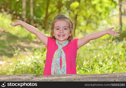 little girl enjoying and raising her hands in park