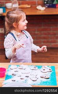 Little girl enjoying her baked cookies. Decorating cookies with colorful sprinkle and icing sugar. Kid taking part in baking workshop. Baking classes for children, aspiring little chefs. Learning to cook. Combining and stirring prepared ingredients. Real people, authentic situations