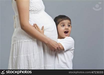 Little girl excited after listening to pregnant womans stomach