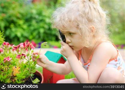 Little girl exploring nature with a magnifying glass