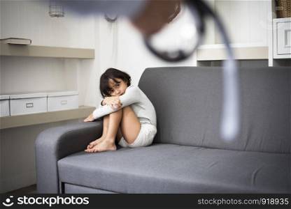 Little girl fearing her parents from punishing on sofa in dramatice moment.Children's Rights in Early Childhood Education and Social and parrents care problem concept