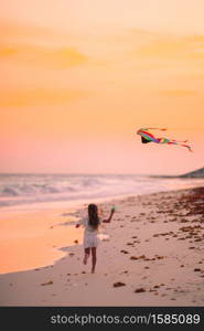 Little girl flying a kite on the beach. Little girl flying a kite on the beach with turquiose water