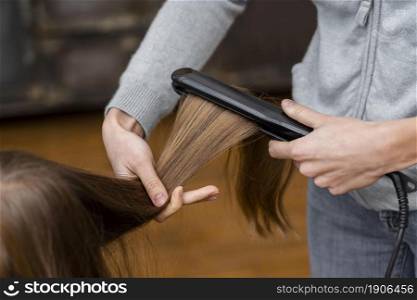 little girl getting her hair straightened. High resolution photo. little girl getting her hair straightened. High quality photo