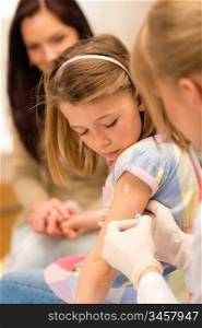 Little girl getting vaccination from pediatrician at medical office