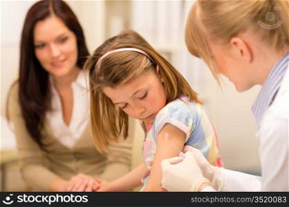 Little girl getting vaccination from pediatrician at office