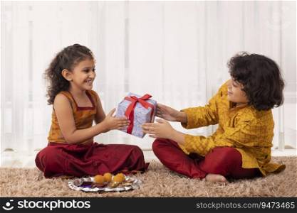 Little Girl giving gift to her brother on the occasion of Bhai Dooj