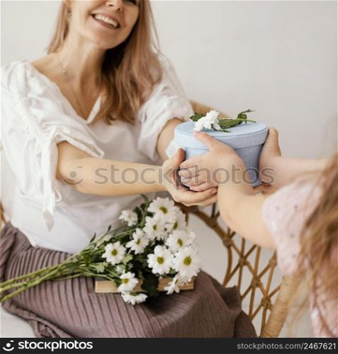 little girl giving spring flowers gift box mom