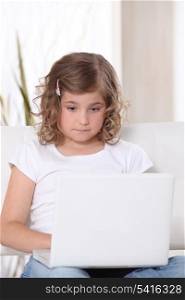 Little girl glued to laptop screen
