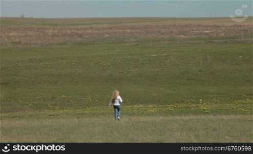 Little girl go away through a spring field